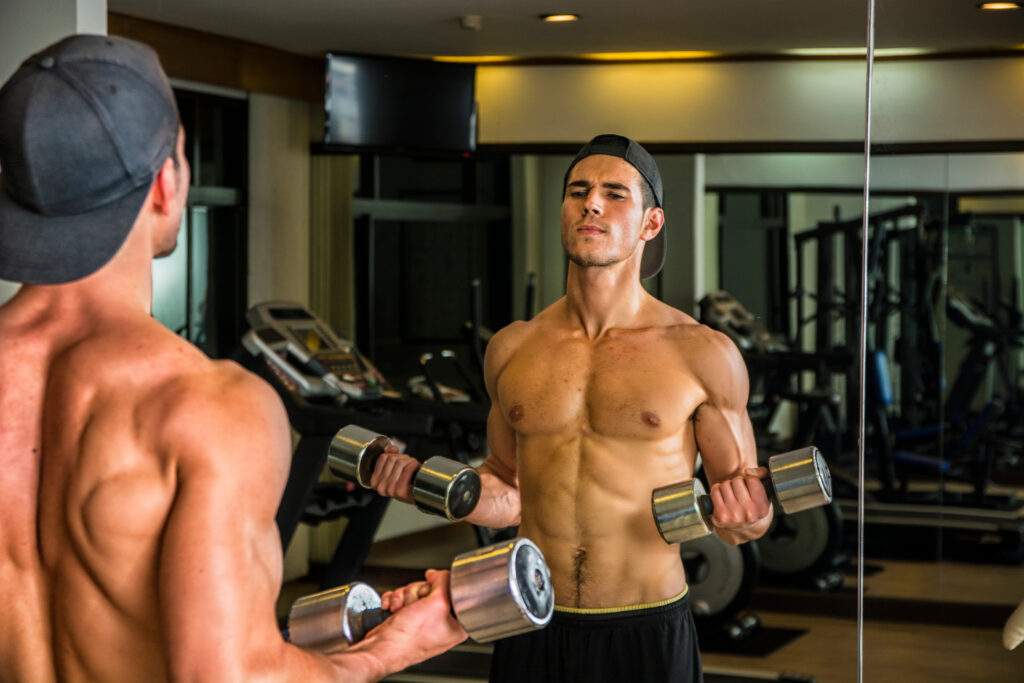 A person lifting weights in a gym to build bigger shoulders